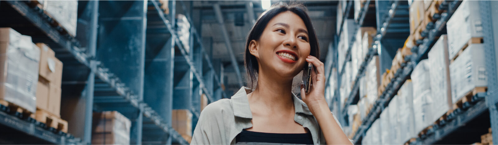 A woman on the phone inside a large warehouse