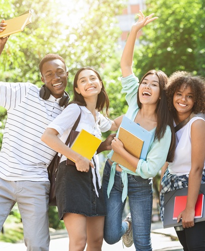 Portrait of joyful college students posing outdoors after passing exam